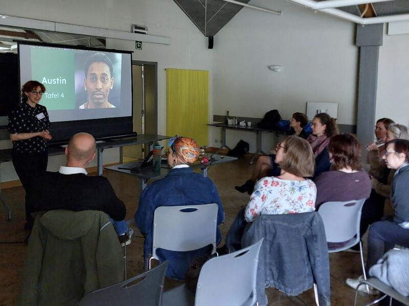 A presenter speaking to Empathy Lab participants in front of a projected persona slide