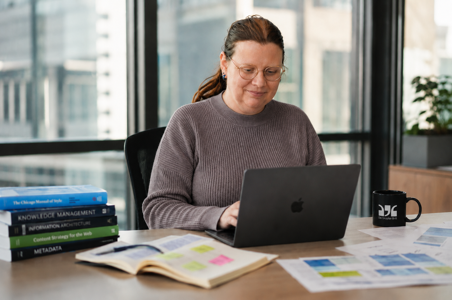 Working at a desk with publishing reference books and a De Gruyter Brill mug